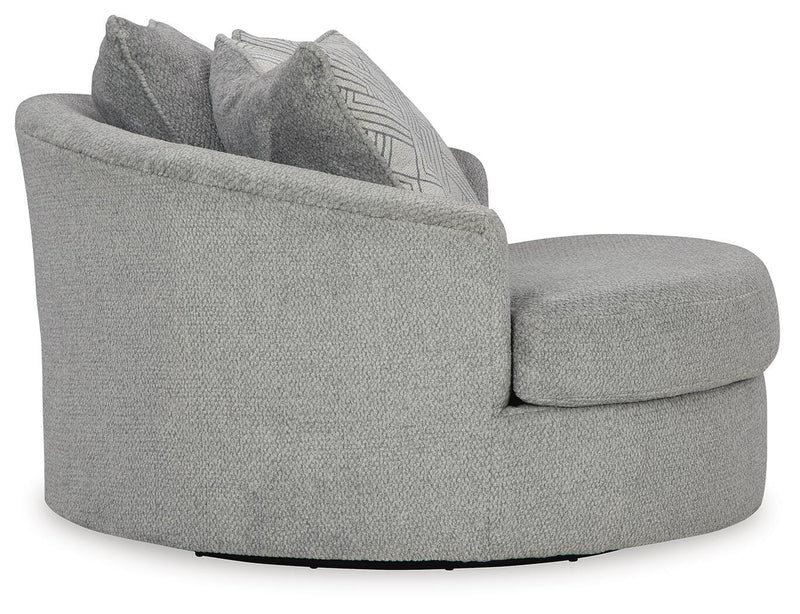 Ashley Furniture Casselbury oversized swivel accent chair in beige fabric, shown from the side with plush cushioning and a rounded back.