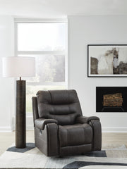 Ashley Furniture Femley recliner in dark brown fabric with plush cushioning and padded armrests, shown from a front angle.