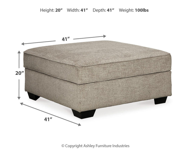 Ashley Furniture Bovarian Ottoman with plush fabric upholstery and wooden legs, showcasing a stylish and functional living room accent piece.
