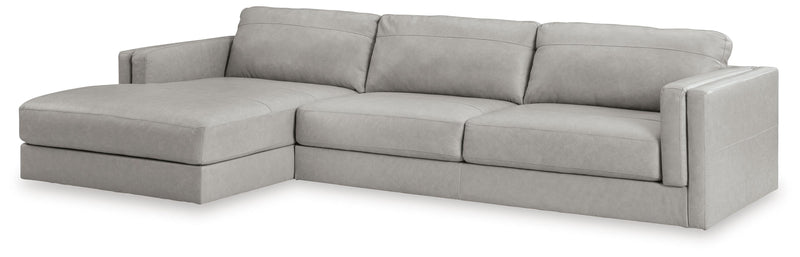Ashley Furniture Amiata sectional with chaise showing beige upholstered fabric and modern design from an angled view.