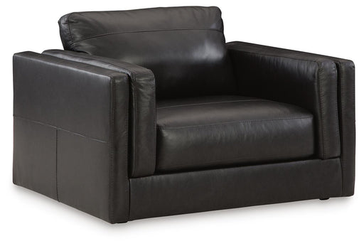 A large Ashley Furniture Amiata oversized chair with plush fabric and wide armrests, shown from an angled side view.