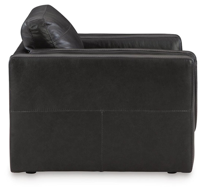 A beige Amiata Oversized Chair by Ashley Furniture with plush cushions and a modern design, shown from the side view.