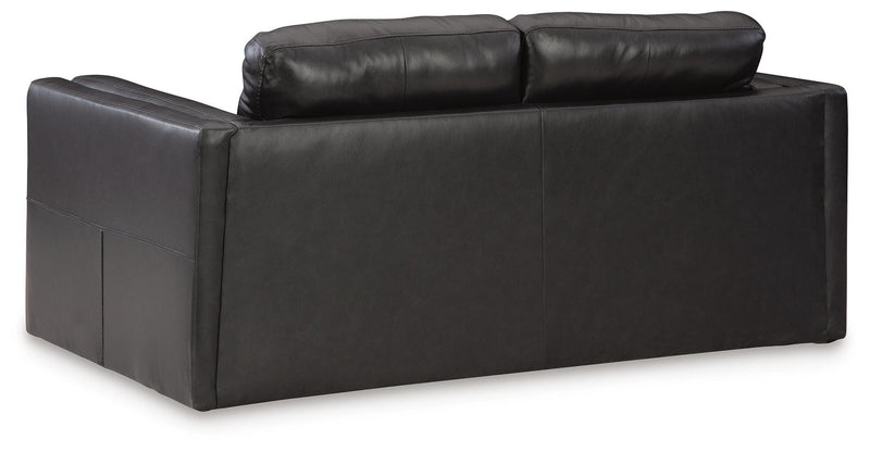 Ashley Furniture Amiata Loveseat with plush cushions and wooden legs, shown from the back view.