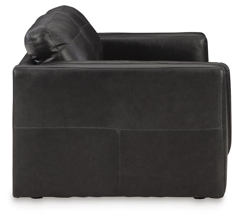 Ashley Furniture Amiata loveseat with plush fabric and modern design, shown from a side angle in a cozy living room setting.
