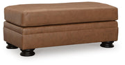 Ashley Furniture Carianna Ottoman with plush fabric and wooden legs, shown from an angled view.