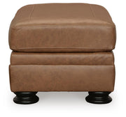 Ashley Furniture Carianna Ottoman showing a plush fabric top and wooden legs, placed as a versatile living room accent piece.