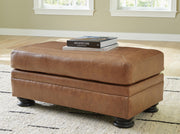 Ashley Furniture Carianna Ottoman with wooden legs and cushioned fabric top, designed for living room seating and decor.