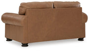 Ashley Furniture Carianna loveseat with plush fabric and cushioned backrest, shown from the rear in a cozy living room setting.