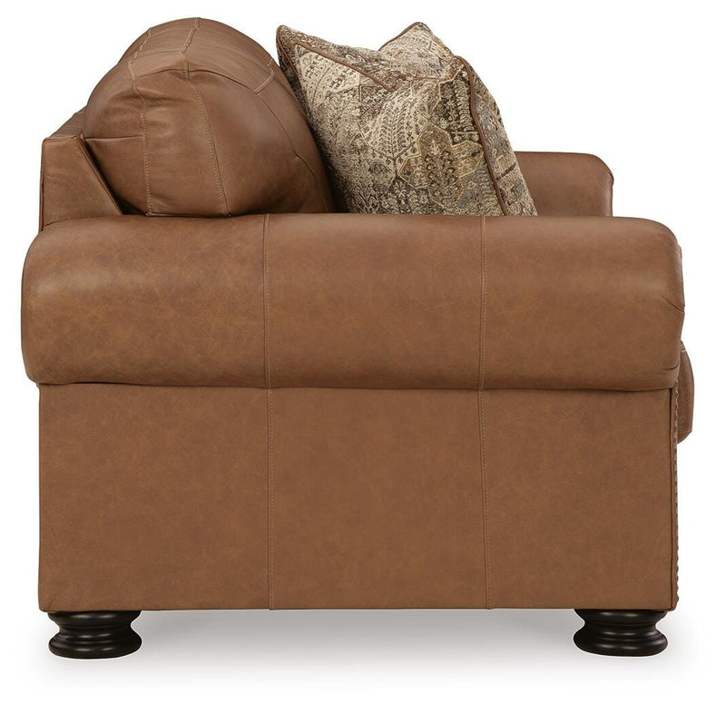 Ashley Furniture Carianna loveseat with plush fabric and cushioned armrests, shown from a side angle.