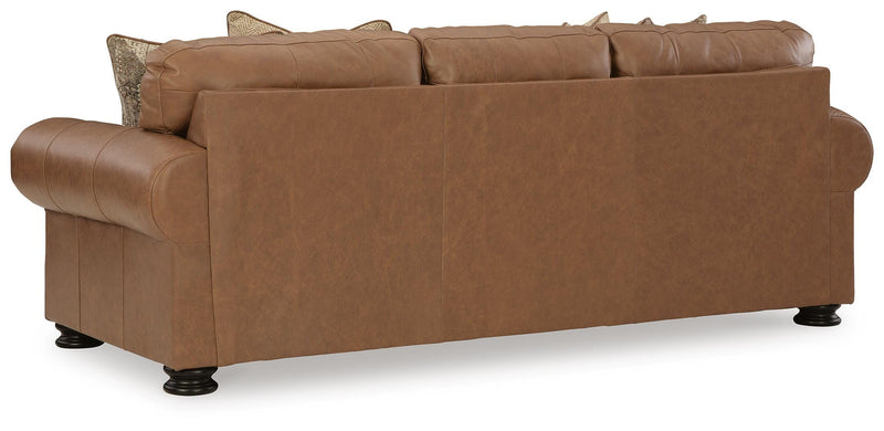 Ashley Furniture Carianna Sleeper Sofa with plush back cushions and wooden legs, shown from the back in a modern living room setting.