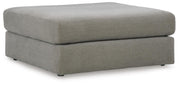 Ashley Furniture Avaliyah oversized accent ottoman with plush fabric and sturdy wooden legs, shown from a side angle.