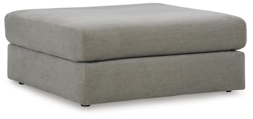 Ashley Furniture Avaliyah oversized accent ottoman with plush fabric and sturdy wooden legs, shown from a side angle.