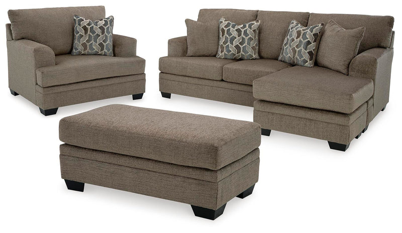 Ashley Furniture Stonemeade living room set with beige upholstered sofas and armchairs arranged in a cozy seating area.