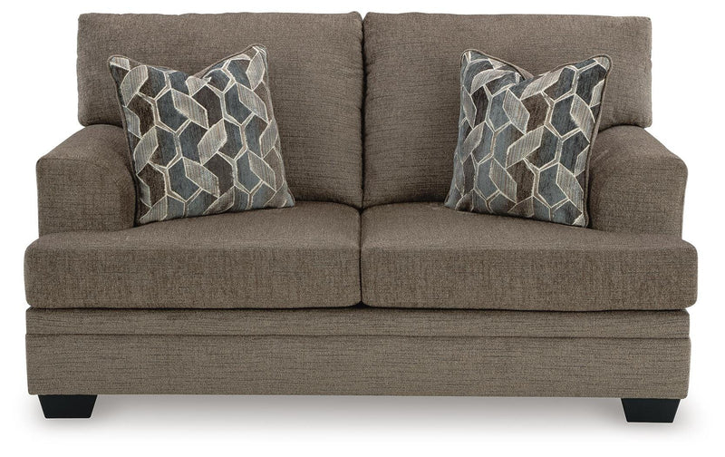 Ashley Furniture Stonemeade living room set showing a beige sofa, loveseat, and armchair with plush cushions and wooden legs.