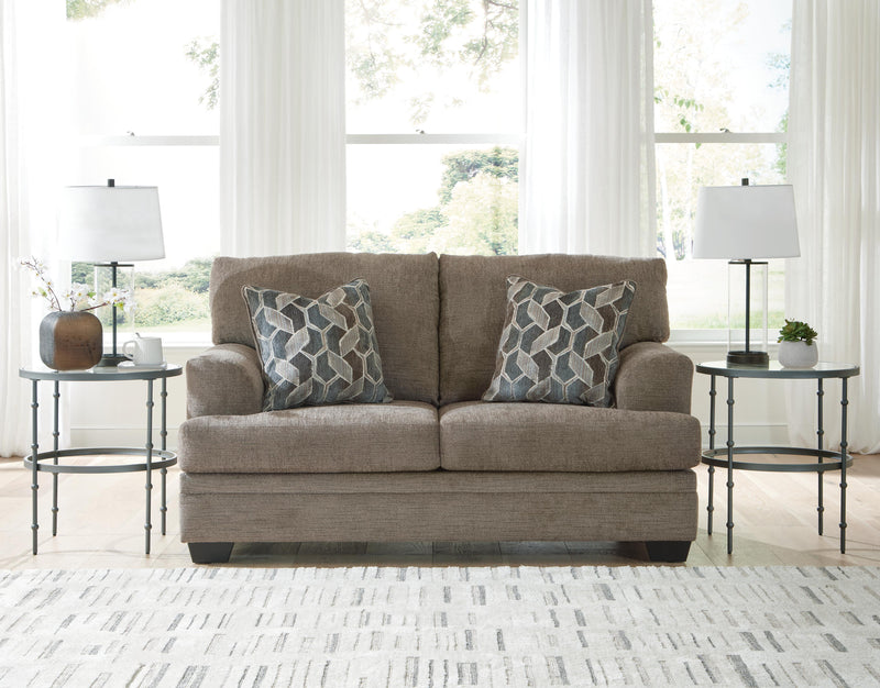 Ashley Furniture Stonemeade living room set with sofa and loveseat, upholstered in neutral fabric with decorative cushions.