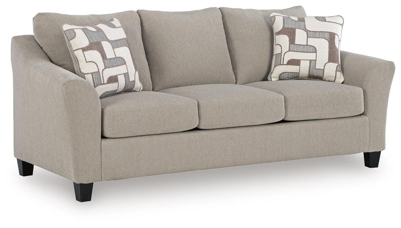 Ashley Furniture Willarae Sofa Sleeper shown in an angled view, featuring a modern design with plush cushions and wooden legs.