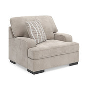 Ashley Furniture high profile living room set with chair and ottoman, featuring plush cushions and modern design in a cozy setting.