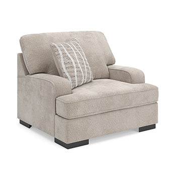 Ashley Furniture high profile living room set with chair and ottoman, featuring plush cushions and modern design in a cozy setting.