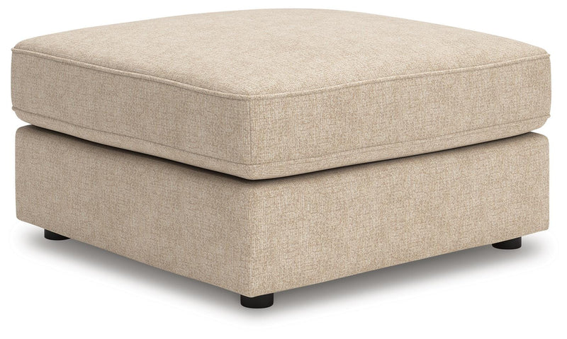 Ashley Furniture Seyler oversized accent ottoman with plush fabric and wooden legs, shown from an angled view.