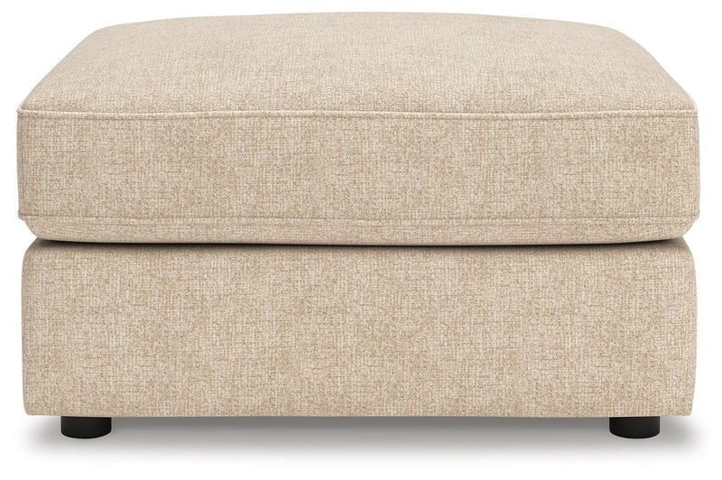 Ashley Furniture Seyler oversized accent ottoman with plush fabric and tufted top, shown in a head-on view.