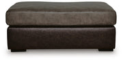 Ashley Furniture Castille Way oversized accent ottoman with plush fabric and a neutral beige color, shown from a front head-on view.