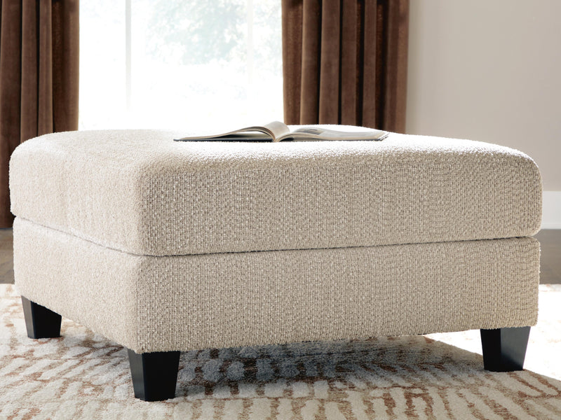 Ashley Furniture Steelwater Retreat oversized accent ottoman with plush fabric and sturdy wooden legs in a modern design.