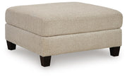 Steelwater Retreat oversized accent ottoman by Ashley Furniture, shown from an angle with plush fabric and sturdy wooden legs.