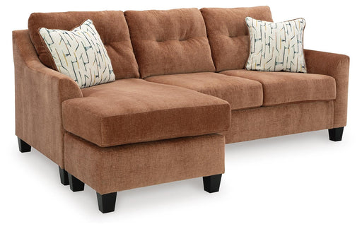 Ashley Furniture Amity Bay sofa chaise sleeper with plush fabric, angled view showing the extended chaise and cozy sleeping area.