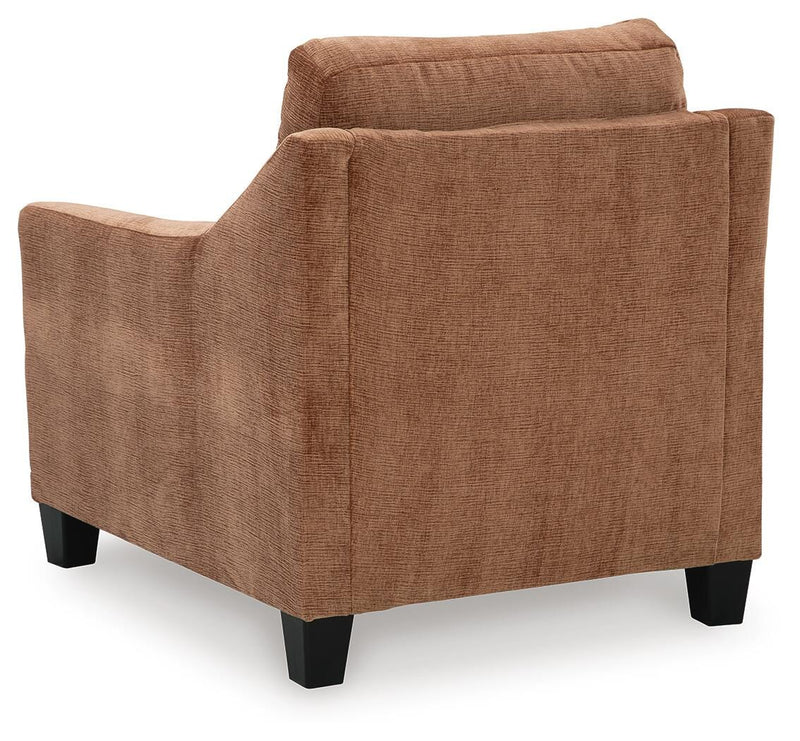 Ashley Furniture Amity Bay Chair with plush fabric upholstery and wooden legs, shown from the back in a cozy living room setting.