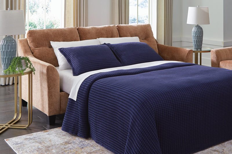 Ashley Furniture Amity Bay sofa chaise sleeper showing plush fabric, chaise lounge section, and convertible sleeper feature.