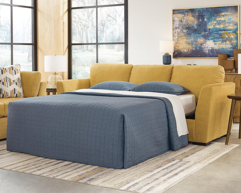 Ashley Furniture Keerwick Sleeper Sofa with beige upholstery and modern design, shown in a cozy living room setting.