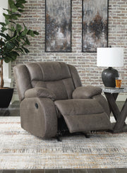 Open view of Ashley Furniture First Base Recliner showing plush brown upholstery and cushioned armrests.
