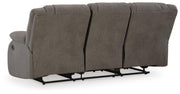Ashley Furniture First Base reclining sofa with plush cushions and dark fabric upholstery, shown from the back.