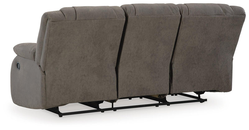 Ashley Furniture First Base reclining sofa with plush cushions and dark fabric upholstery, shown from the back.