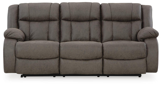 Ashley Furniture First Base Reclining Sofa in neutral fabric, showing plush cushions and reclining mechanism from a front view.