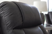 Ashley Furniture Mackmenville reclining sofa with plush fabric, visible stitching, and cushioned armrests in a modern living room setting.