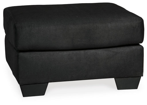 Ashley Furniture Darcy Ottoman with plush fabric and wooden legs, showcasing a stylish and versatile ottoman design.