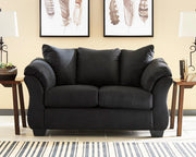 Ashley Furniture Darcy Loveseat with plush fabric and cushioned arms, shown in a cozy living room setting.