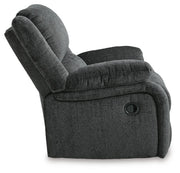 Ashley Furniture Draycoll recliner in brown leather with cushioned armrests and plush back support, shown from the side.