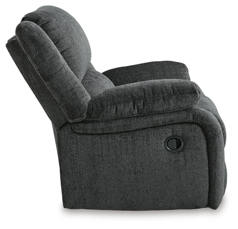 Ashley Furniture Draycoll recliner in brown leather with cushioned armrests and plush back support, shown from the side.
