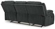 Ashley Furniture Draycoll reclining sofa with plush cushions and reclining feature, shown from the back in a modern living room setting.