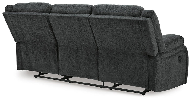 Ashley Furniture Draycoll reclining sofa with plush cushions and reclining feature, shown from the back in a modern living room setting.