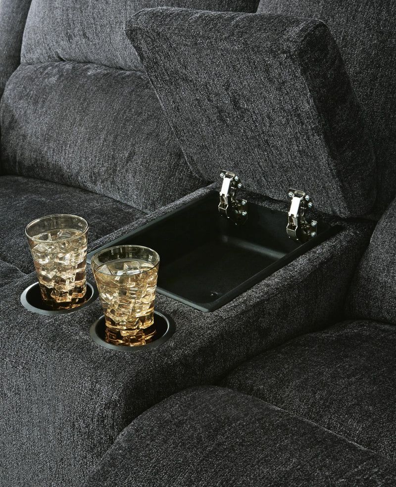 Ashley Furniture Draycoll power reclining loveseat with console, shown in dark gray fabric, featuring plush cushions and built-in cup holders.