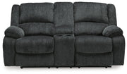 Ashley Furniture Draycoll reclining loveseat with console, shown from head-on view, featuring plush fabric and built-in cup holders.
