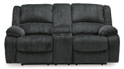 Ashley Furniture Draycoll power reclining loveseat with console, shown from a head-on view, featuring plush cushions and built-in cup holders.