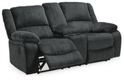 Open-angle view of Ashley Furniture Draycoll reclining loveseat with built-in console, fabric upholstery, and plush cushioning.