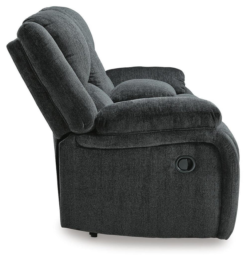 Ashley Furniture Draycoll reclining loveseat with console, showing plush fabric, padded armrests, and built-in cup holders.
