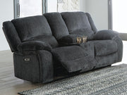 Ashley Furniture Draycoll power reclining loveseat with console, showing plush fabric and built-in cup holders in a modern living room setting.
