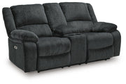 Ashley Furniture Draycoll power reclining loveseat with console, featuring plush upholstery and a modern design, shown from an angled view.