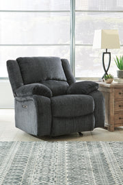 Ashley Furniture Draycoll power recliner with plush upholstery and a closed back, shown in a cozy living room setting.